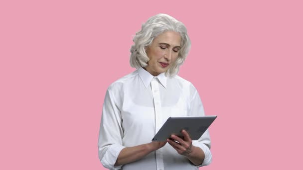 Zâmbind o femeie în vârstă folosind tabletă digitală . — Videoclip de stoc