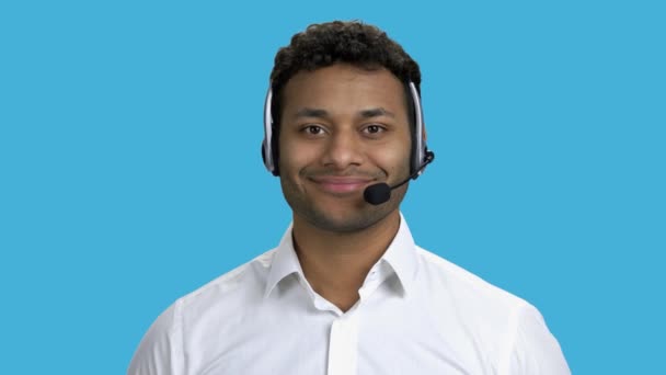 Operador de centro de llamadas sonriente sobre fondo azul. — Vídeos de Stock