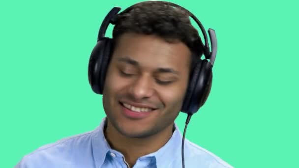Веселий темношкірий чоловік слухає музику в навушниках . — стокове відео