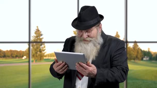 Sorrindo homem sênior assistindo vídeo em tablet digital. — Vídeo de Stock