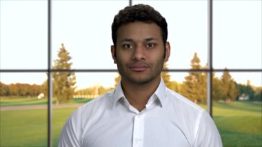 Yakından gülümseyen yakışıklı iş adamı kameraya bakıyor..