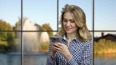 Cep telefonuyla internette sörf yapan güzel bir kadın..