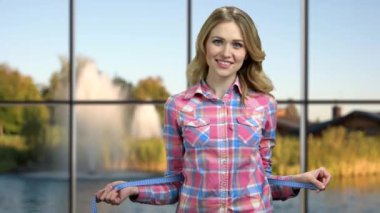 Genç, neşeli kadın belini ölçüyor..