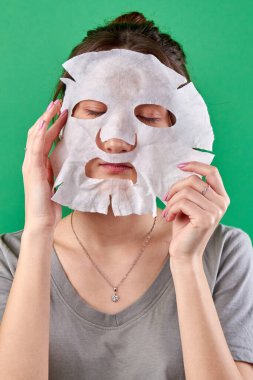 Kağıt kaplıca maskesi takan bir kızın portresi.