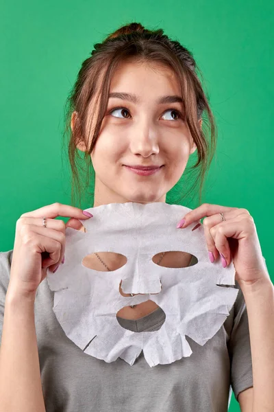Attraente ragazza che tiene maschera foglio di carta. — Foto Stock