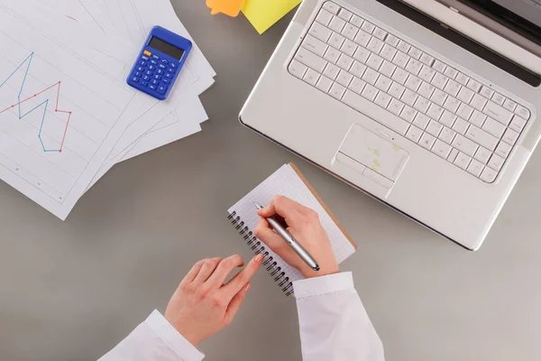 Vrouwelijke hand maken notities in notebook. — Stockfoto