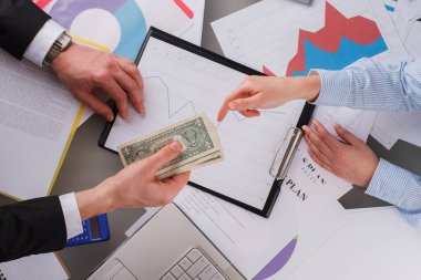 İşadamı ofisteki kadın işçiye para veriyor..