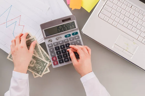 Mani femminili utilizzando la calcolatrice alla scrivania in ufficio. — Foto Stock