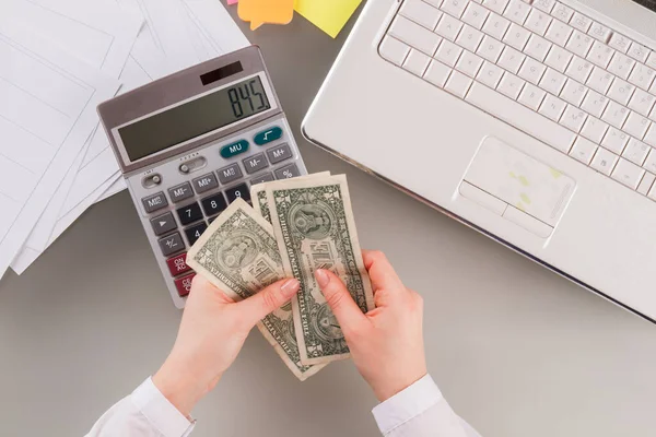 Donna d'affari utilizzando calcolatrice e tenendo i soldi. — Foto Stock