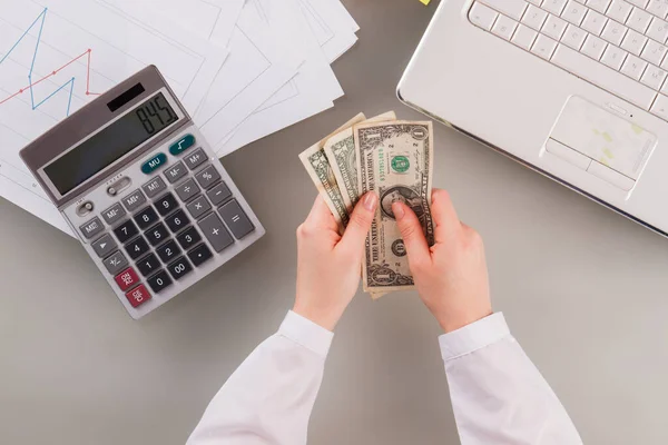 Mulher de negócios segurando dinheiro analisando gráficos de renda. — Fotografia de Stock