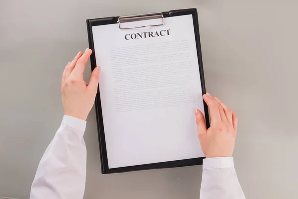 Female hands holding clipboard with business contract. — Stock Photo, Image