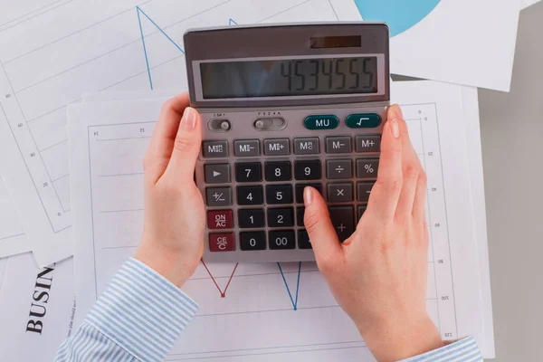 Mani di donna d'affari che lavora con la calcolatrice. — Foto Stock