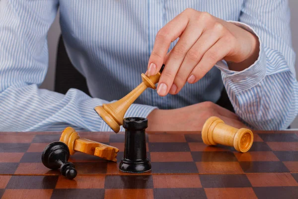 Primer plano manos de mujer de negocios jugando ajedrez juego. — Foto de Stock