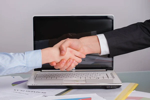 Empresário e empresária apertando as mãos sobre a mesa. — Fotografia de Stock