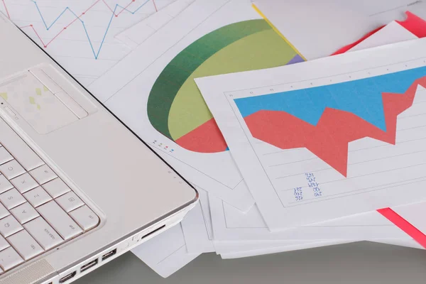 Cierre de papeles financieros y laptop. — Foto de Stock