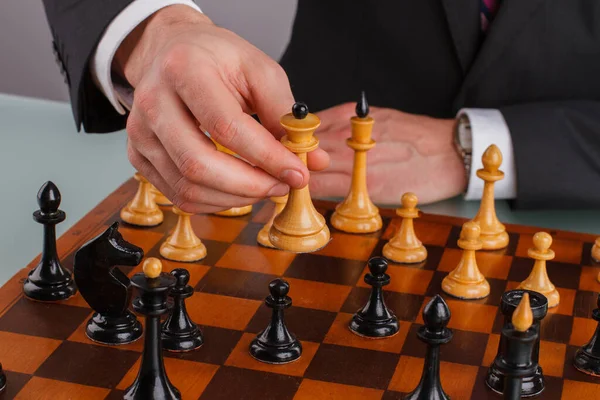 Primer plano hombre de negocios mano jugando ajedrez. — Foto de Stock