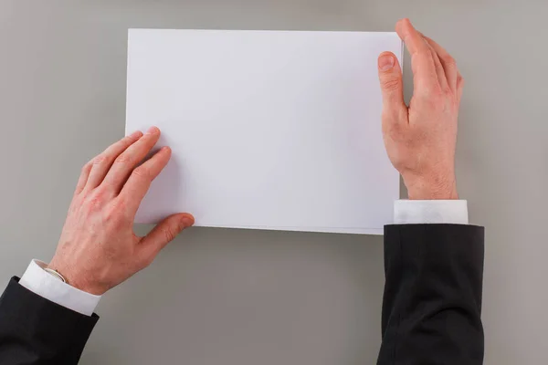 Χέρια επιχειρηματία κρατώντας κενό φύλλο χαρτιού. — Φωτογραφία Αρχείου
