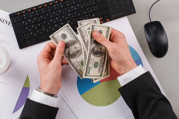 Empresário contando dinheiro com computador e papéis no escritório. — Fotografia de Stock