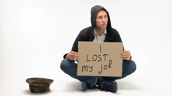 Young caucasian jobless man begs money with hat. — Stock Photo, Image