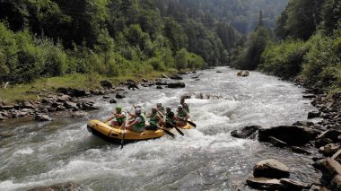 Can yeleği giymiş insanlar kürek çekiyor..