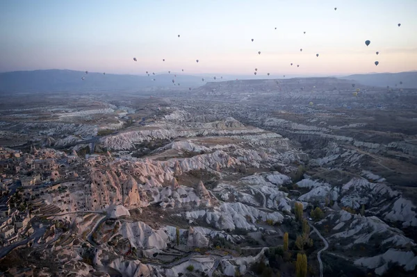 Paisaje con globos de aire caliente volando sobre las montañas de la antigua ciudad cueva Uchisar. — Foto de Stock