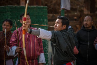 Erkekler okçulukta yarışıyor. Bhutan 'ın Ulusal Kıyafetleri.