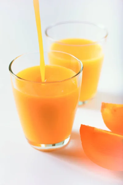Bardağa dökülen ince bir damla meyve suyu ile taze meyve suyu.