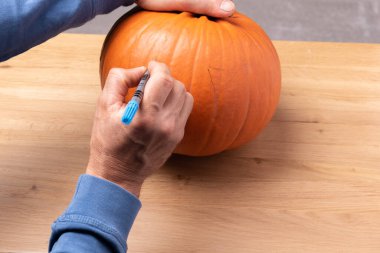 Balkabağına Jack-o-fener çizmek. Gülen Cadılar Bayramı Balkabağı Tatil Süslemesi.