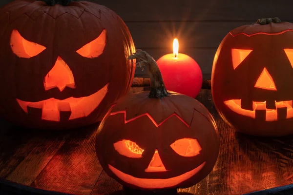 Cadılar Bayramı balkabağı kafalı, korkunç şeytani yüzleri ve mumları olan bir balkabağı. Mevsimlik aydınlatılmış dekorasyon.