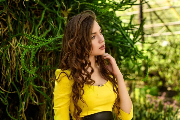 노랗게 여름옷을 초목이 우거진 정원에서 아름다운 코카서스 소녀의 — 스톡 사진
