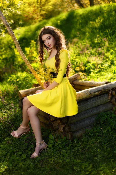 よく絵の上に座って黄色のドレスの美しい若い女性 グロー — ストック写真