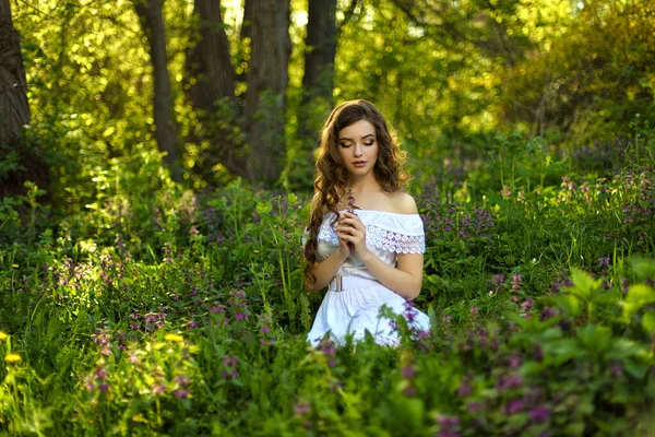 Όμορφη Νεαρή Κοπέλα Λευκό Φόρεμα Κάθεται Στο Γρασίδι Στον Κήπο — Φωτογραφία Αρχείου