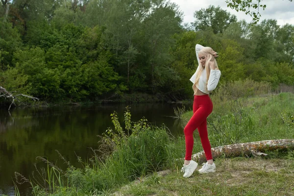 Jeune Blonde Pantalon Rouge Haut Blanc Baskets Relaxantes Près Rivière — Photo