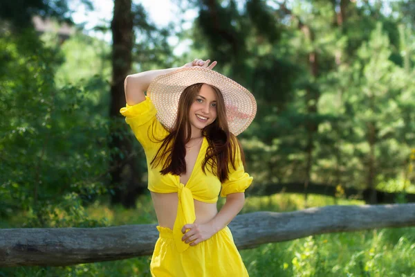 在夏天的公园里 穿着黄色衣服的漂亮的年轻女子放松了下来 戴帽子的漂亮姑娘 — 图库照片