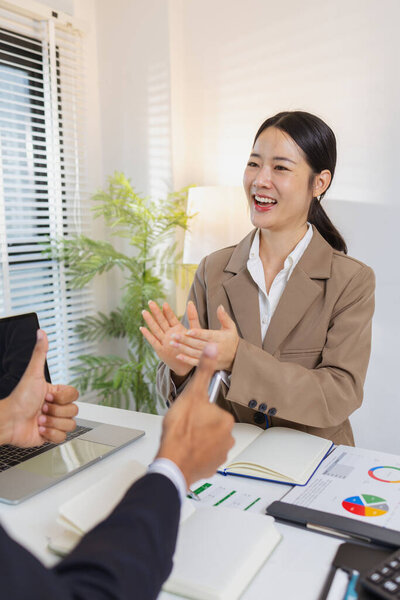 Двое коллег празднуют успешную дискуссию веселыми выражениями лица и хлопанием в ладоши. Их позитивное взаимодействие отражает командную работу, мотивацию и удовлетворенность после просмотра отчетов.