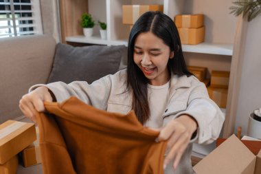 Müşterilere gönderilmek üzere ürünleri memnuniyetle kutulara dolduruyor, bir girişimci alıcılara, paketlere, paketlere, paketlere, küçük işletmelere, hazırlıklara gönderilecek ürünleri hazırlıyor