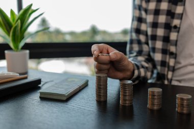 Gelecek planları için para biriktiriyor, gelirini kumbaraya yatırıyor, acil durumlar için para ve banknotlar biriktiriyor, madeni paralar üst üste yığılıyor, para kazanıyor.