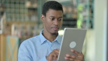 Dijital Tablet kullanan Hırslı Afrikalı Genç Adamın Portresi