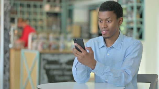 Ambitiös ung afrikansk man firar framgång på Smart Phone — Stockvideo