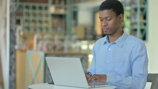 在咖啡店使用笔记本电脑的聚焦非洲年轻人 — 图库视频影像