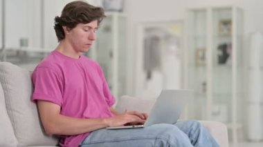 Evde dizüstü bilgisayar öksürüğü kullanan hasta bir genç adam. 