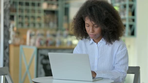 Junge afrikanische Geschäftsfrau mit Laptop lächelt in Kamera im Cafe — Stockvideo