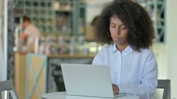 Empresaria africana enfocada trabajando en computadora portátil en café — Vídeo de stock