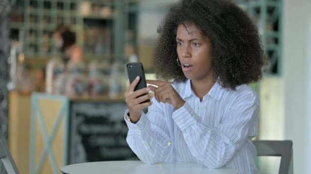 在智能手机上遭受损失的失望的年轻非洲女商人 — 图库视频影像