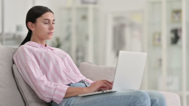 Fatigué jeune femme latine avec ordinateur portable ayant la douleur au cou à la maison — Video