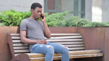 Genç Afrikalı Adam Bench 'te Smartphone' da Konuşuyor 
