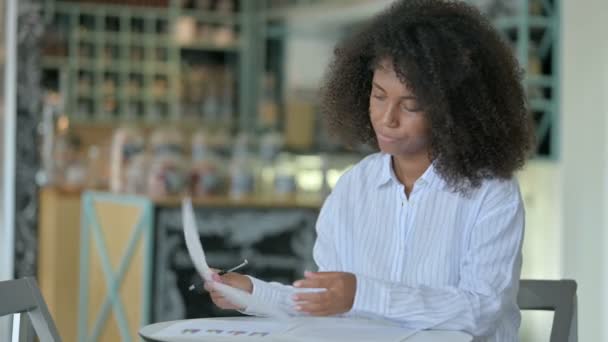 认真的非洲年轻女商人在咖啡店做文书工作 — 图库视频影像