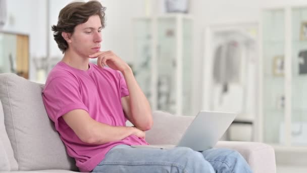Pensive Young Casual Man χρησιμοποιώντας Laptop στο σπίτι — Αρχείο Βίντεο