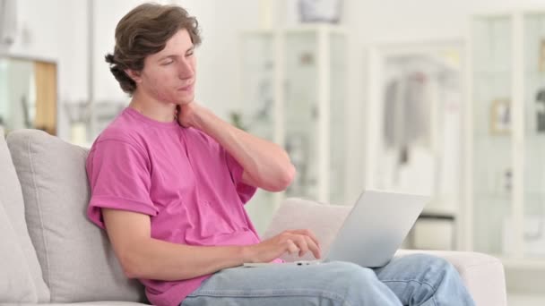 Νεαρός Casual άνθρωπος με φορητό υπολογιστή που έχει πόνο στο λαιμό στο σπίτι — Αρχείο Βίντεο