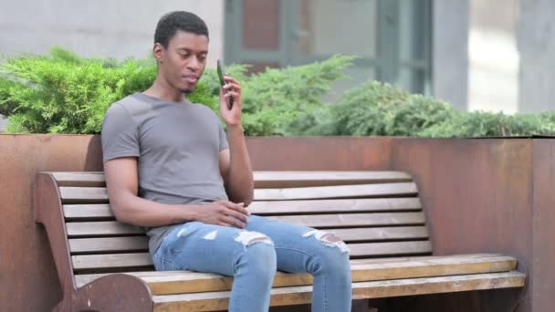 Joven africano ambicioso celebrando el éxito en Smartphone — Vídeos de Stock